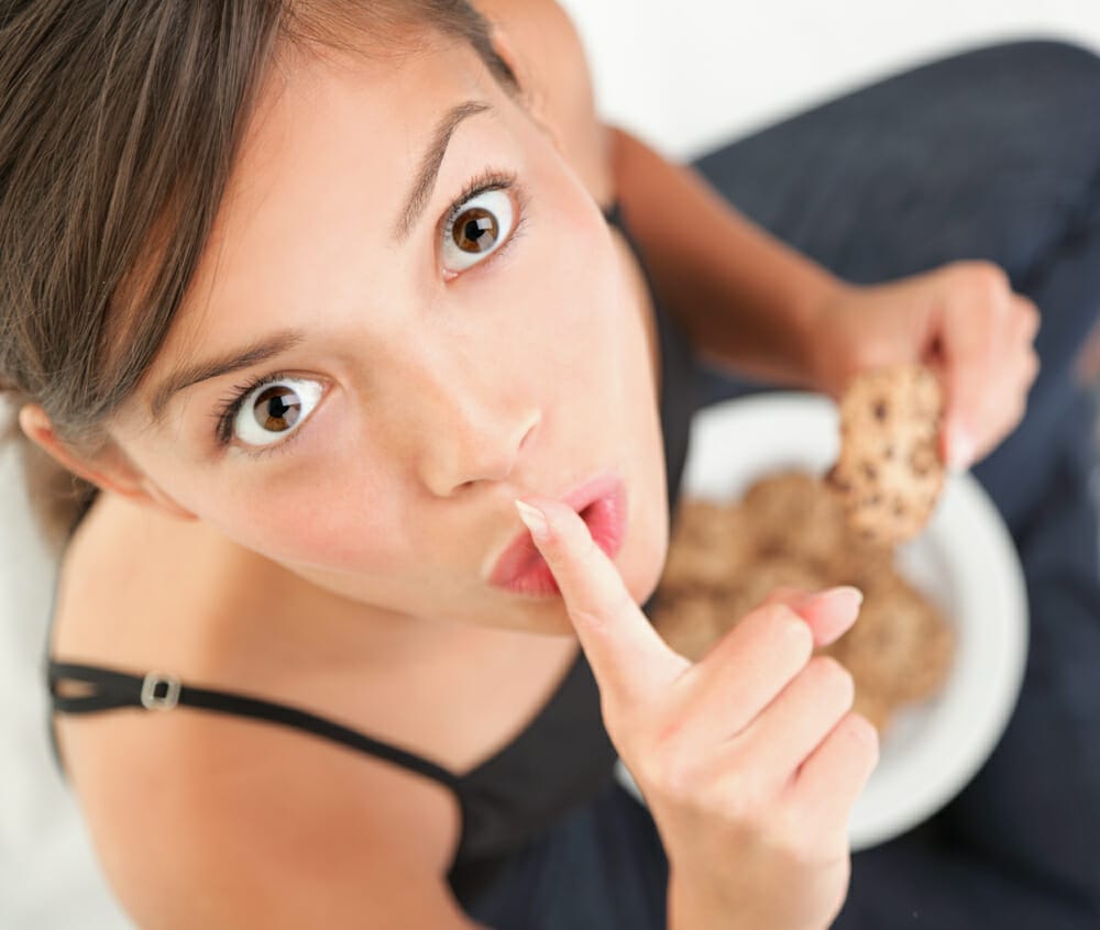  μια γυναίκα τρώει κρυφά γλυκά
