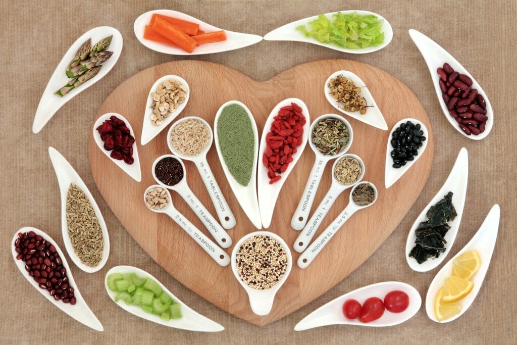  Βότανα και άλλα υγιεινά προϊόντα βρίσκονται πάνω σε μια σανίδα κοπής σε σχήμα καρδιάς