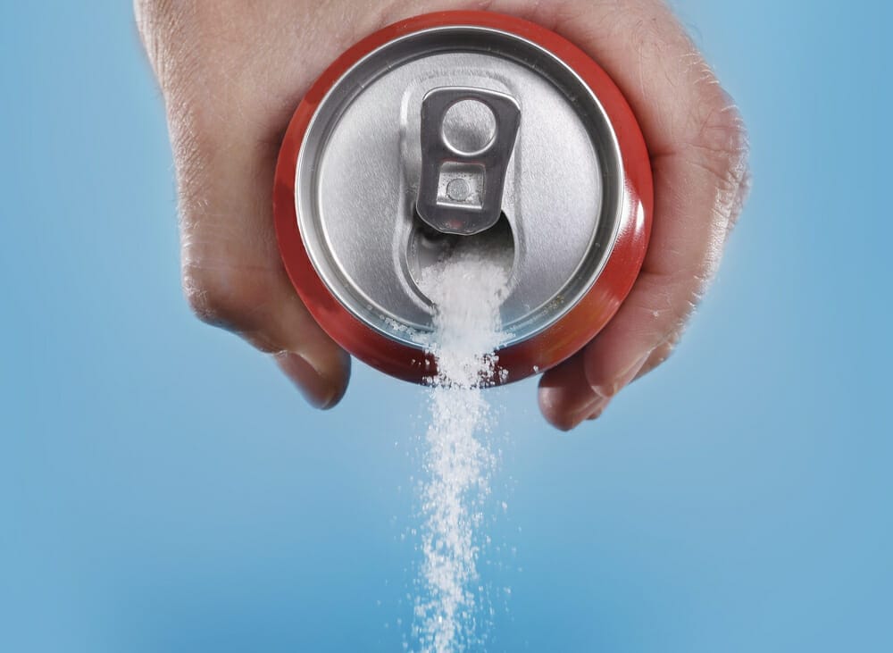  λευκή ζάχαρη ξεχειλίζει από ένα κουτάκι coca cola